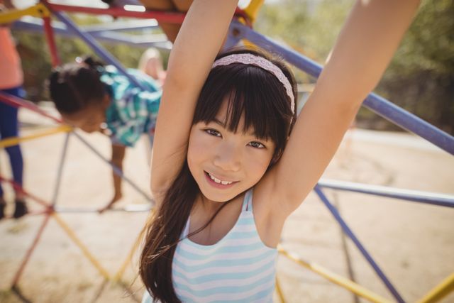 Young girl enjoying time on dome climber at school playground. Ideal for use in educational materials, advertisements for playground equipment, or articles about childhood development and outdoor activities.