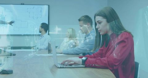 Businesswoman typing on laptop in boardroom during meeting with holographic overlay