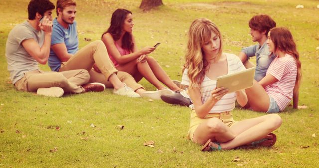 Young Adults Relaxing in Park while Using Tablets and Smartphones - Download Free Stock Images Pikwizard.com