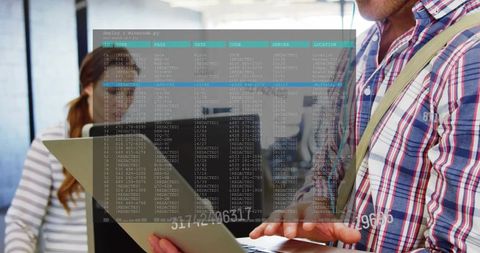 Man presenting laptop and typing with terminal code overlay in modern open-plan office