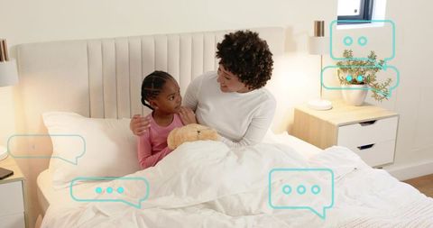 Mother comforting daughter in bed with teddy during cozy bedtime routine and conversation