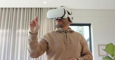 Man engaging in virtual reality at home with joyful expression
