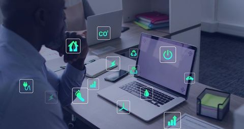 Man Evaluating Sustainable Office Technology with Energy Efficiency and Recycling Icons