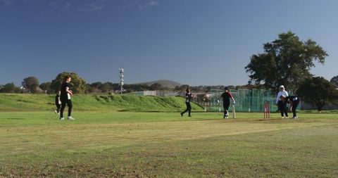 Female Cricketers Playing Enthusiastically in Sunny Park Setting