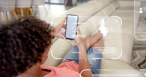Reclining man using smartphone with augmented reality shopping interface on leather sofa