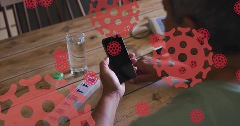 Man at home checking smartphone surrounded by virus symbols