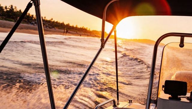 Sunset motorboat cutting wake along tropical coastline with canopy and gps navigation