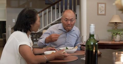 Senior Asian Couple Enjoying Dinner Sharing Joyful Moments at Home