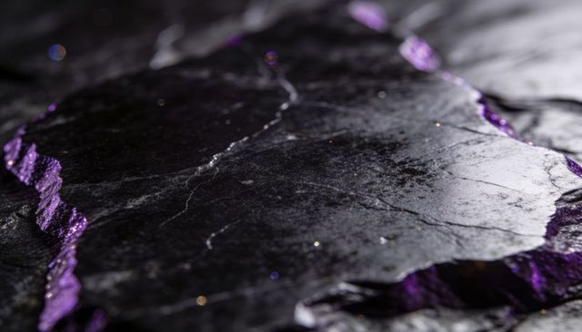 Glittering black slate slab showing hairline fissures and violet rims macro mineral texture
