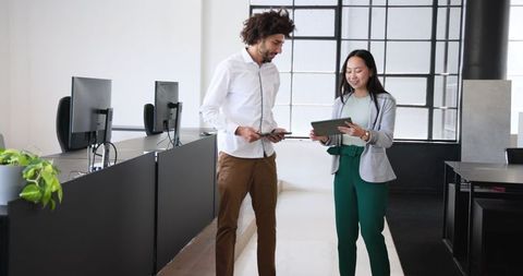 Young Professionals Discussing Project with Tablets in Modern Office