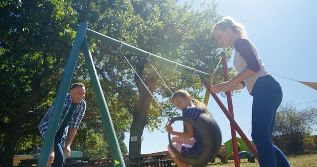 Family Enjoying Outdoor Fun at Playground with Swinging Child - Download Free Stock Images Pikwizard.com