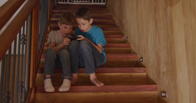 Two Children Sitting on Stairs Playing with a Mobile Phone - Download Free Stock Images Pikwizard.com