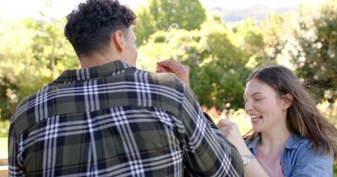 Happy Couple Enjoying Quality Time Blowing Bubbles Outdoors