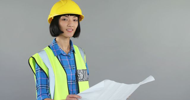 Asian Female Engineer Holding Blueprint in Safety Gear - Download Free Stock Images Pikwizard.com