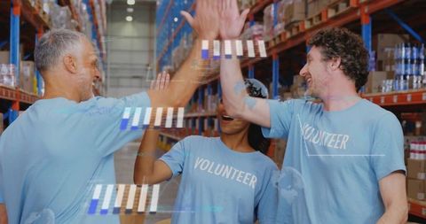 High-fiving volunteers celebrating teamwork in warehouse logistics and donation packing