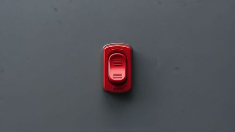 Red rocker switch slider on gray panel, red alert button concept
