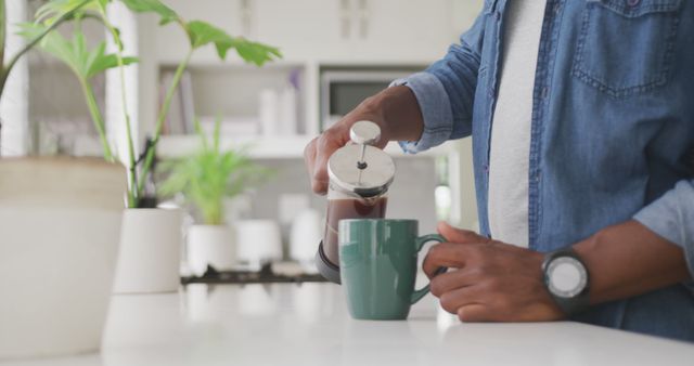 Man Pouring Freshly Brewed Coffee from French Press into Green Mug in Modern Kitchen - Download Free Stock Images Pikwizard.com