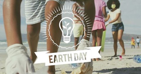 Youth cleaning beach during earth day community cleanup collecting plastic bottles