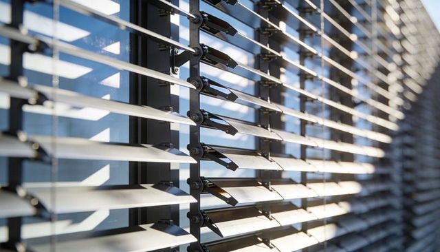 Modern Exterior Sunshade Louvers Reflecting Sky on Glass Curtain Wall with Black Brackets