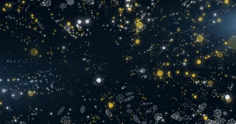 Glowing winter snowflake bokeh with gold and blue sparkle particles on dark backdrop