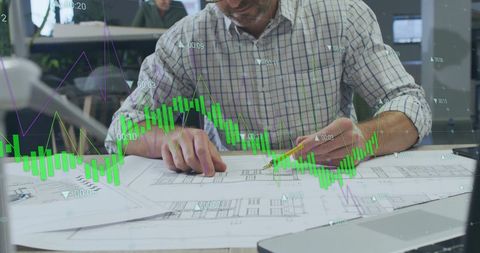 Architect working on blueprints with data overlays