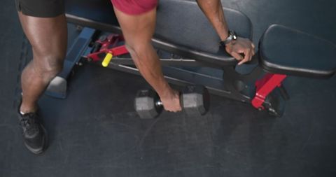 Man performing one-arm dumbbell row exercise at gym