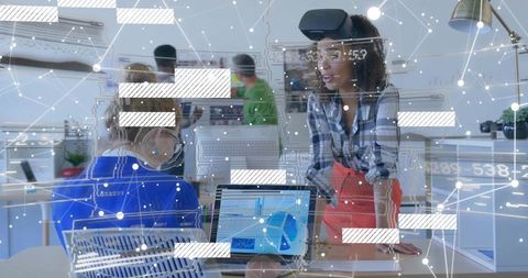 Woman Wearing VR Headset Discussing Data Visualization in Tech Office