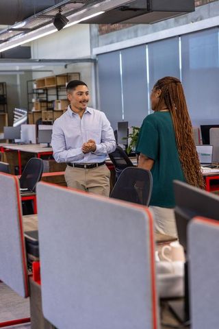Diverse coworkers engaging in discussion in modern office space