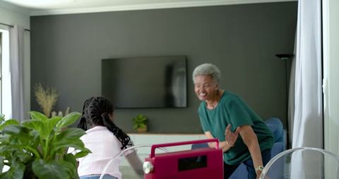 African american grandparent and grandchild sharing joyful moment in bright living room
