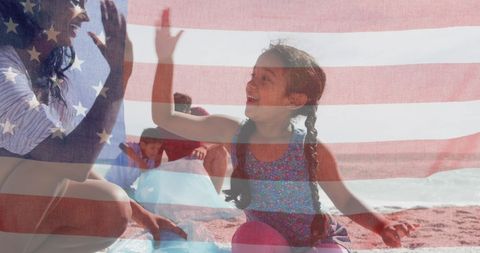 American Flag Over Biracial Family Enjoying Beach Together