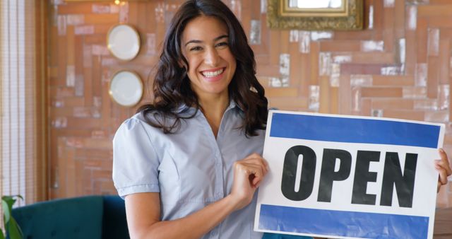 Smiling Woman Holding Open Sign in Cozy Small Business - Download Free Stock Images Pikwizard.com