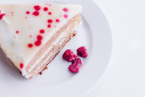 Slice of raspberry vanilla cheesecake on white plate