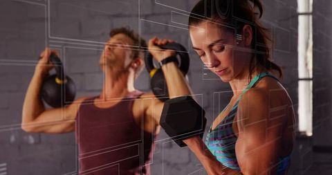 Focused Man and Woman Training with Weights in Urban Gym