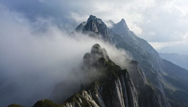 Jagged alpine ridge cutting through low fog on craggy mountain peaks