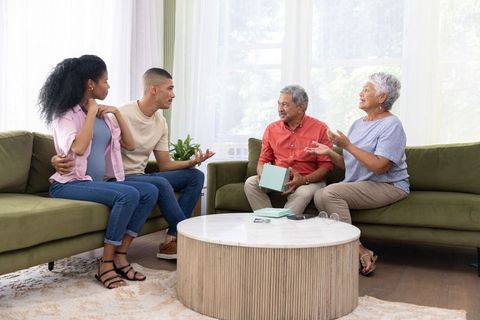 Multigenerational family exchanging gift in bright cozy living room