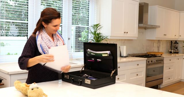 Woman Organizing Papers in Briefcase in Modern Home Kitchen - Download Free Stock Images Pikwizard.com
