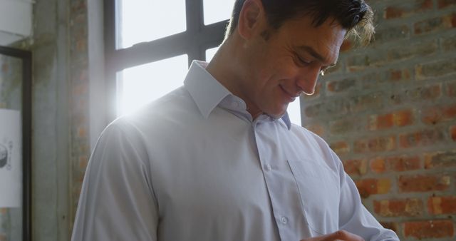 Man in White Shirt Checking His Watch, Standing by Large Window - Download Free Stock Images Pikwizard.com