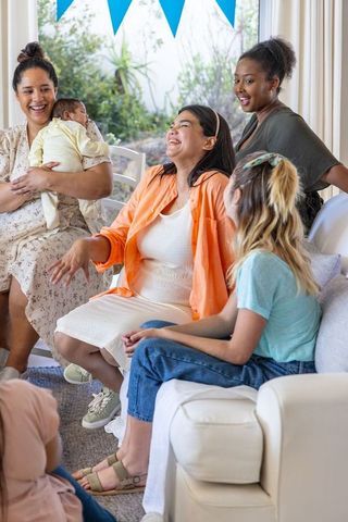 Diverse group of female friends enjoying baby shower celebration