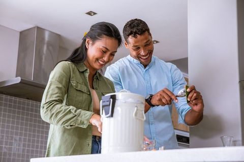 Diverse Couple Sharing Fun Cooking Moment in Modern Kitchen