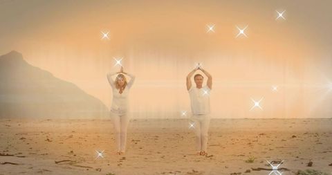 Mature couple practicing yoga on salt flat shoreline at golden hour with sparkling light