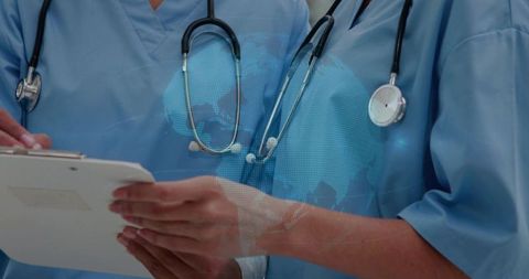 Medical team reviewing digital records with global map overlay for telehealth collaboration