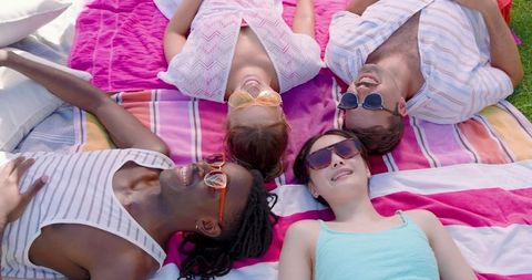 Diverse Group of Friends Enjoying Relaxation Outdoors on Sunny Day