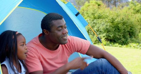 Father and Daughter Bonding in Blue Tent in Nature