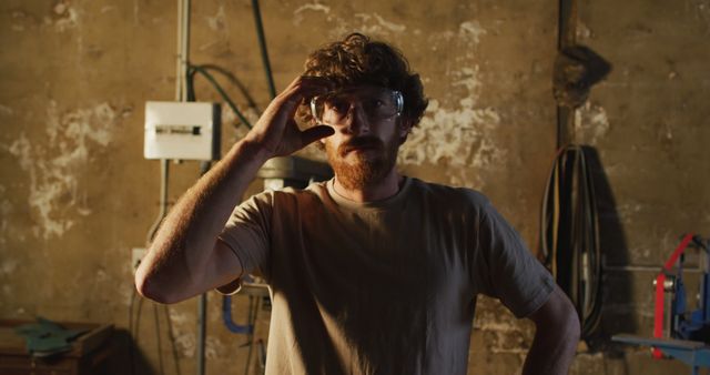 Man Wearing Safety Goggles and Holding Hand to Head in Rustic Workshop - Download Free Stock Images Pikwizard.com