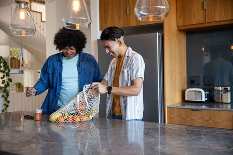 Friends unboxing fruits in modern kitchen