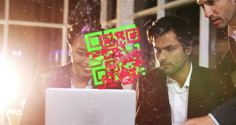 Coworkers Collaborating with Laptop and QR Code Hologram