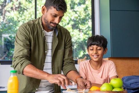 Father and son making sandwiches together in home kitchen