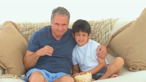 Grandfather and Grandson Watching TV on Couch