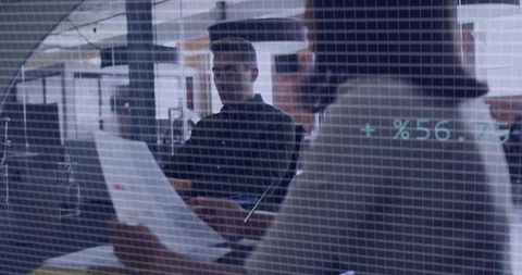 Team Reviewing Document with Digital Data Overlay in Modern Open Office Collaboration