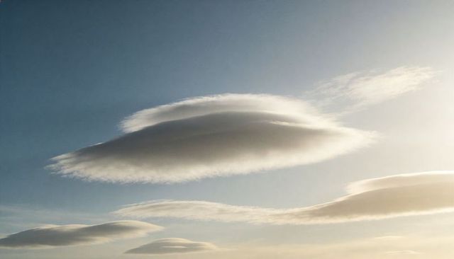 Layered Lenticular Clouds Over Calm Sky During Golden Hour With Sunlit Edges
